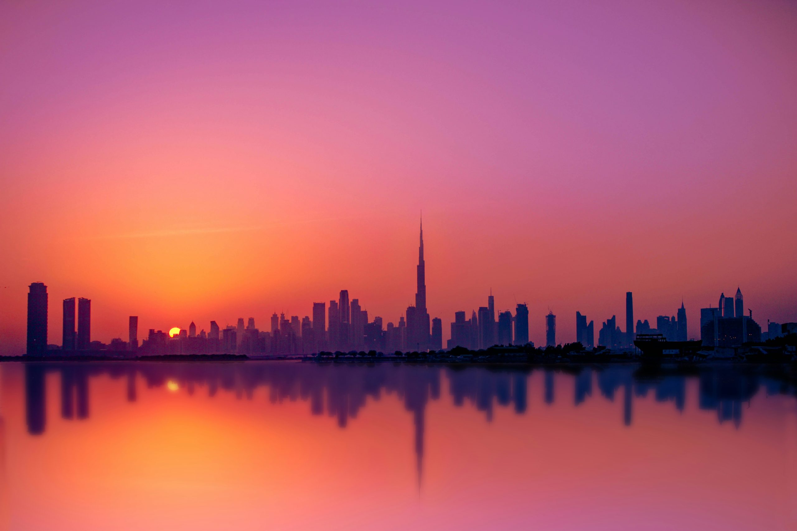 Dubai skyline reflecting on water at sunset