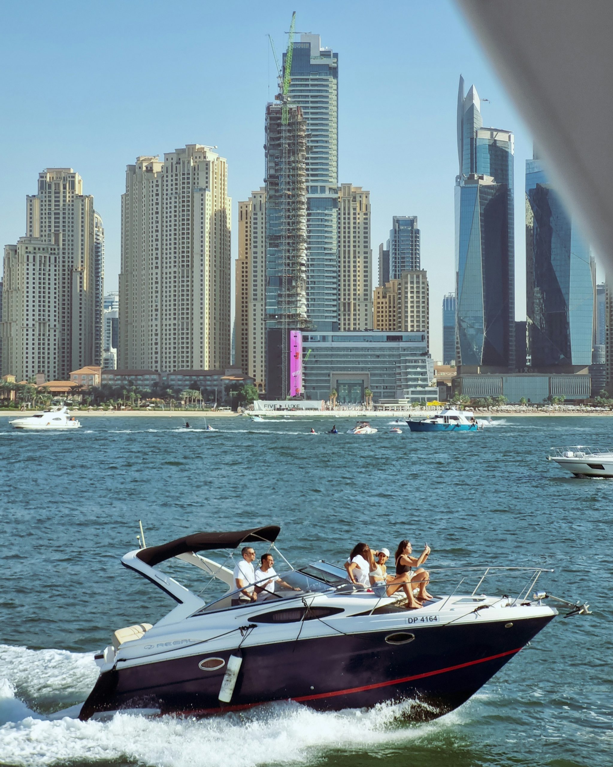 Luxury yacht cruising the Persian Gulf with Dubai skyline in the distance